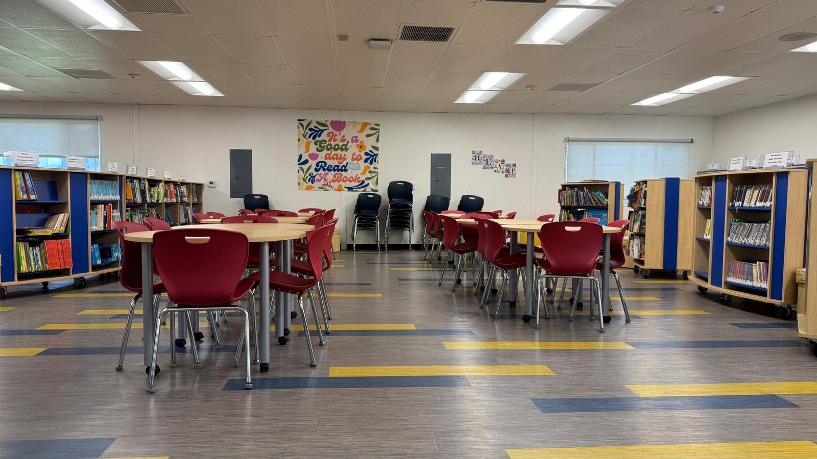 Completed school library with round tables, student chairs and mobile bookshelves