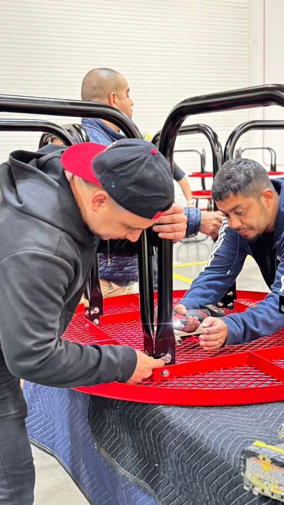 School furniture installers assembling red outdoor cafeteria tables