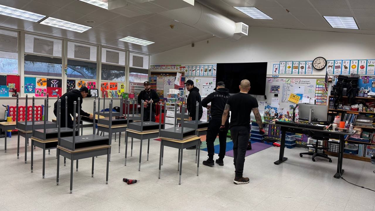 Installation crew assembling student desks inside a classroom