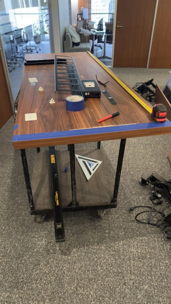 Office work surface with measuring tools and components prepared for furniture assembly