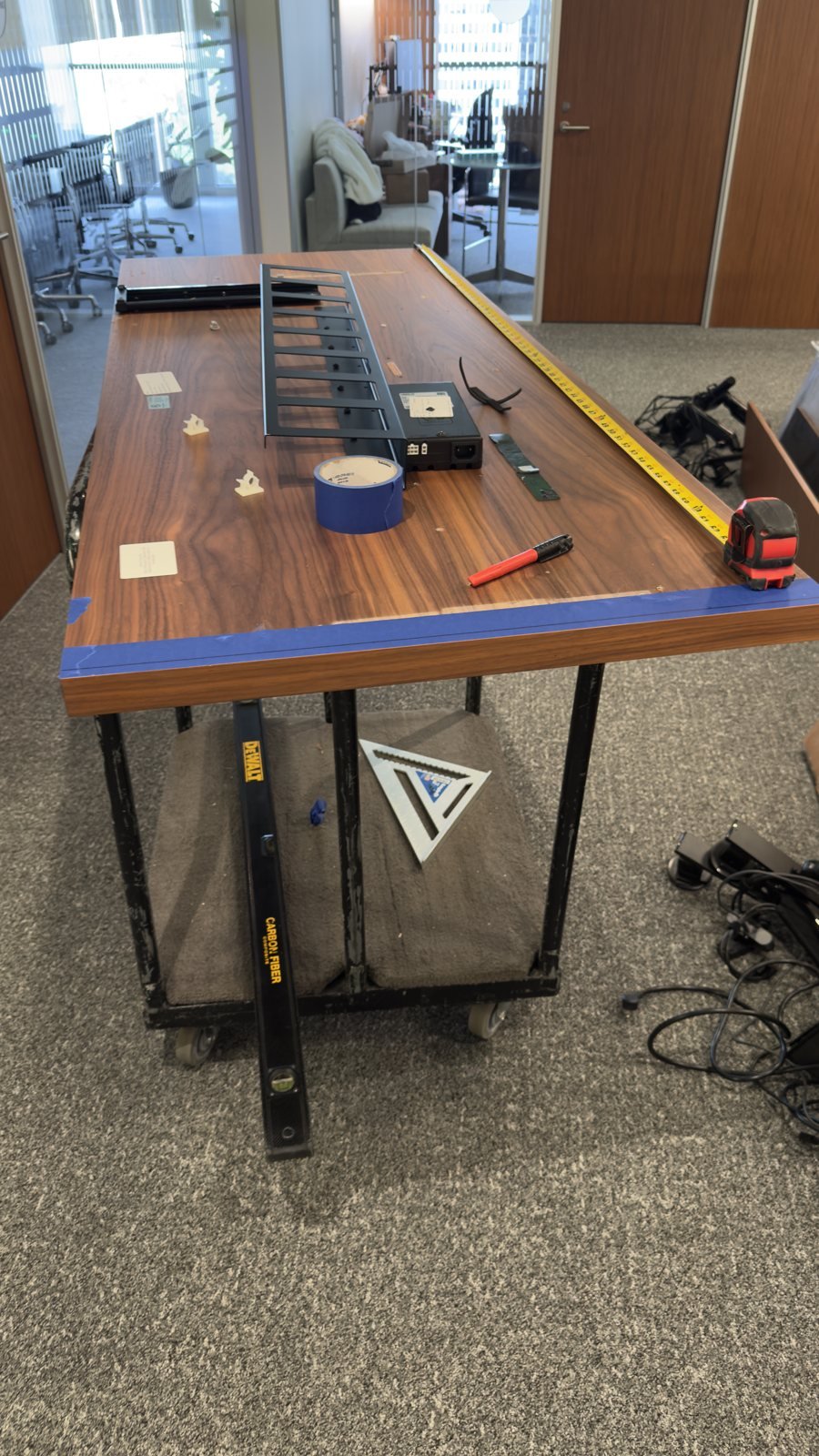 Office work surface with measuring tools and components prepared for furniture assembly