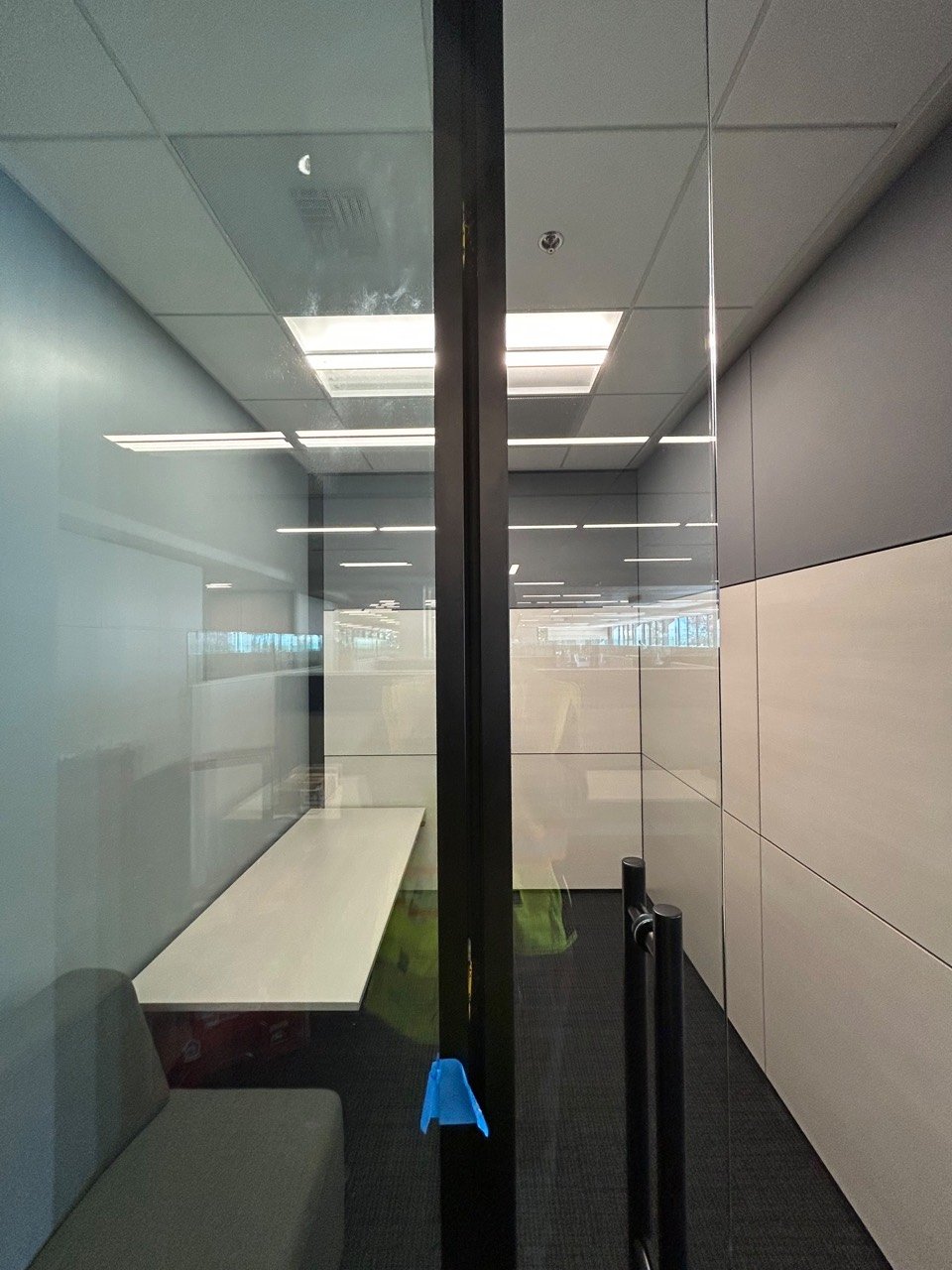 Close view of a glass office door with black frame and handle