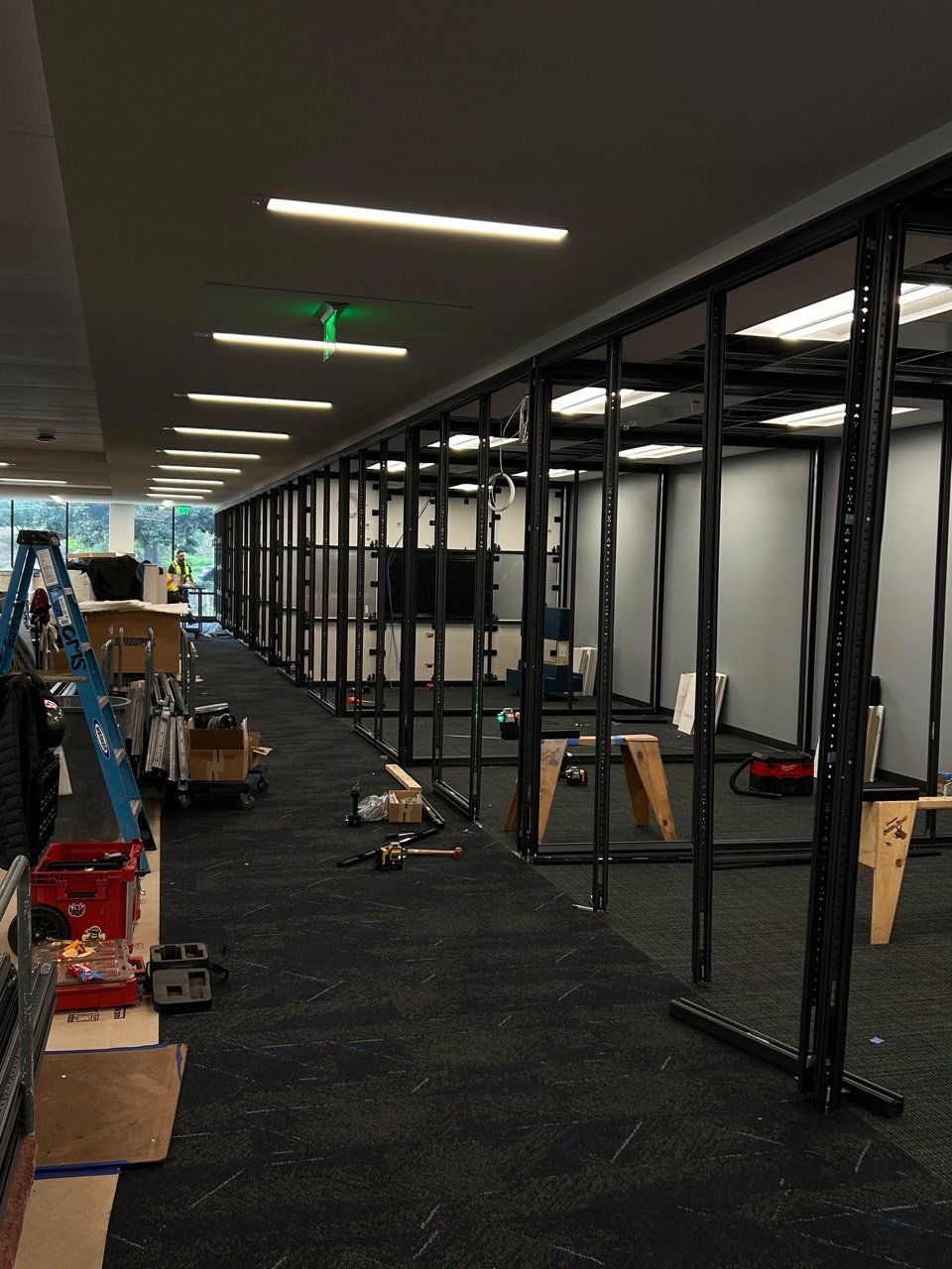 Row of office partition frames being installed along a commercial corridor
